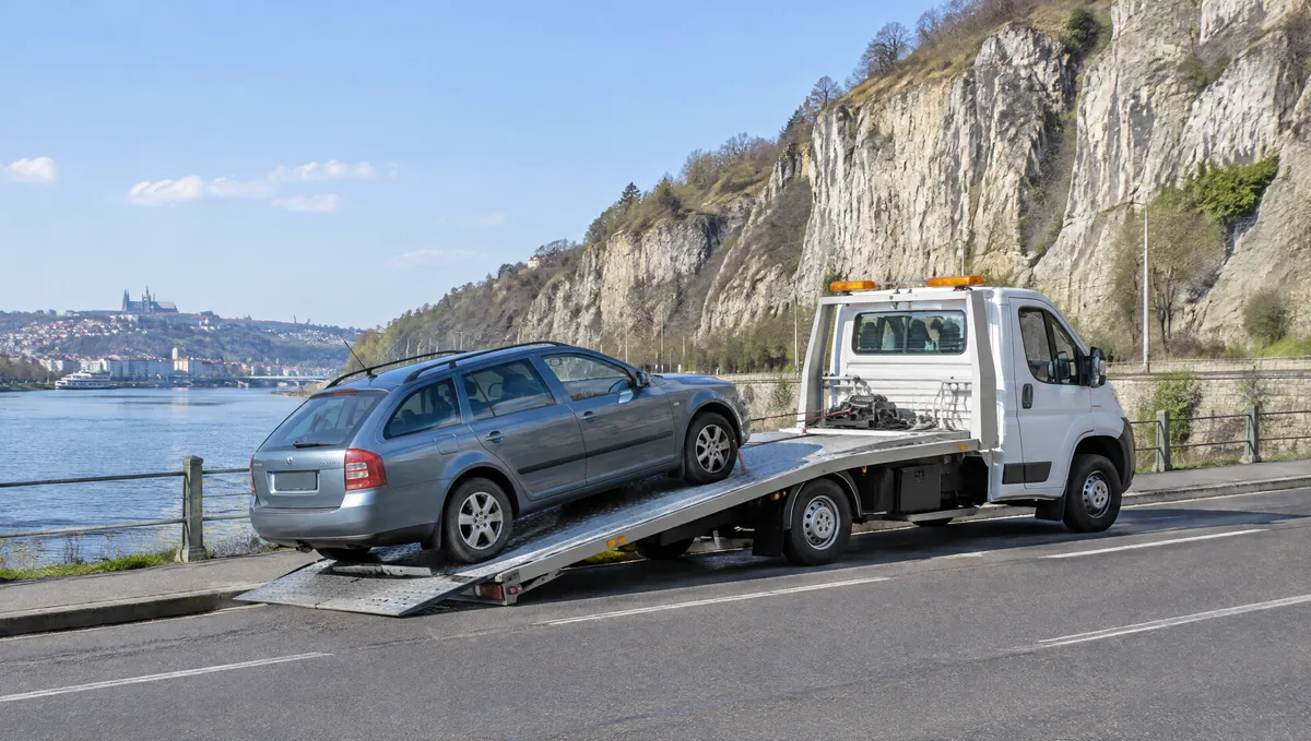 Odtahový vůz nakládá Škodu Octavii combi na Zlíchově pod barrandovskými skalami u Vltavy